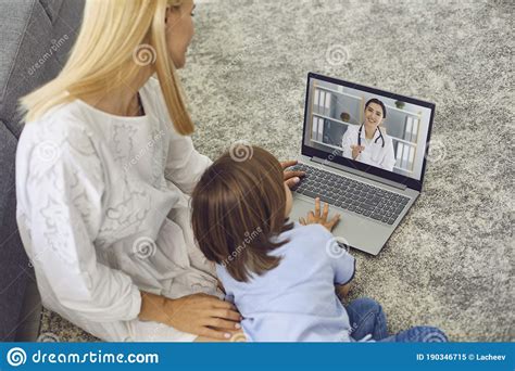 Mother With Son Talking To Doctor Online From Home Parent And Little