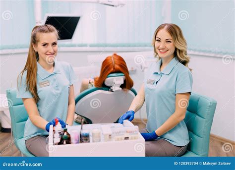 Young Female Dentist And Her Assistant In Dental Clinic Stock Photo