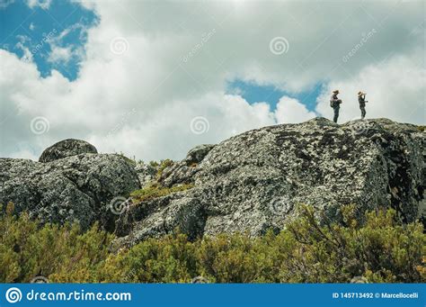 Caminantes Encima De La Formaci N De Roca Con Los Arbustos Fotograf A