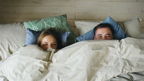 Premium Photo Top View Of Smiling Couple Having Fun In Bed Hiding Under Blanket And Looking