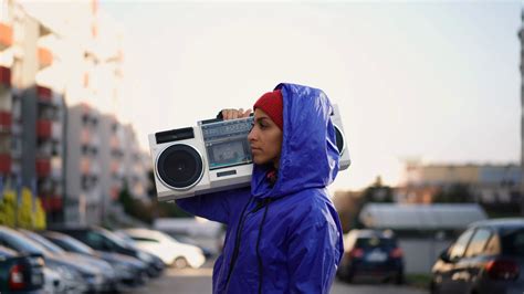 Young Muslim Woman Outdoors In The City Carrying A Stereo Radio And