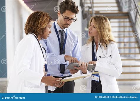 Three Young Male And Female Doctors Consulting Stock Photo Image Of