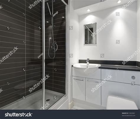 Modern En Suite Bathroom With A Shower Cabin And Dark Ceramic Tiles