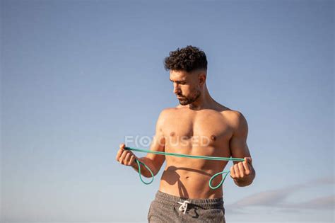 Muscular Culturista Masculino Con Torso Desnudo Parado En La Orilla Del Mar Y Haciendo