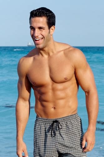 Smiling Happy Tanned Shirtless Man Walking On Beach Showing Six Pack
