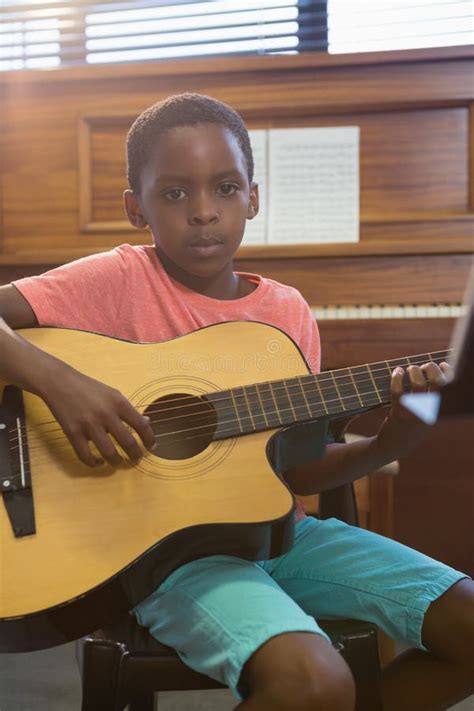 Portrait Of Boy Playing Guitar In Class Stock Photo Image Of Brown