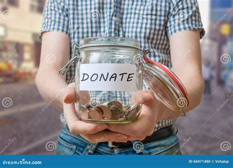 Man Standing On Street Is Collecting Donations In Jar Stock Photo