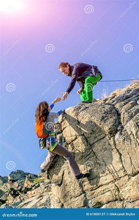 Two Climbers Reaching Summit One Holding Hand Of Stock Image Image Of