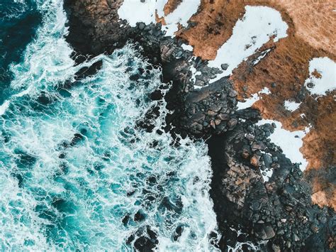 Aerial View Of Ocean Waves Crashing On Rocky Shore · Free Stock Photo
