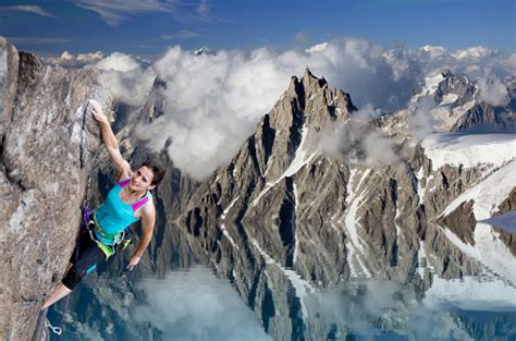 Female Extreme Climber Hanging On Cliff Over The Lake Stock Photo