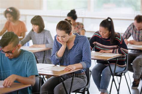 College Students Taking Test At Desks In Classroom Stock Photo Dissolve