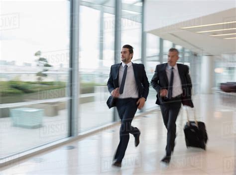 Businessmen Running Rushing With Suitcase In Airport Stock Photo