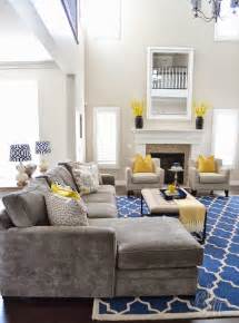 Along with the glossy white painted wooden coffee table, the white upholstery on the sectional english couch is striking and goes with the theme of the area. Client Project Reveal: The Summerwood Project Renovation | Yellow decor living room, Grey and ...