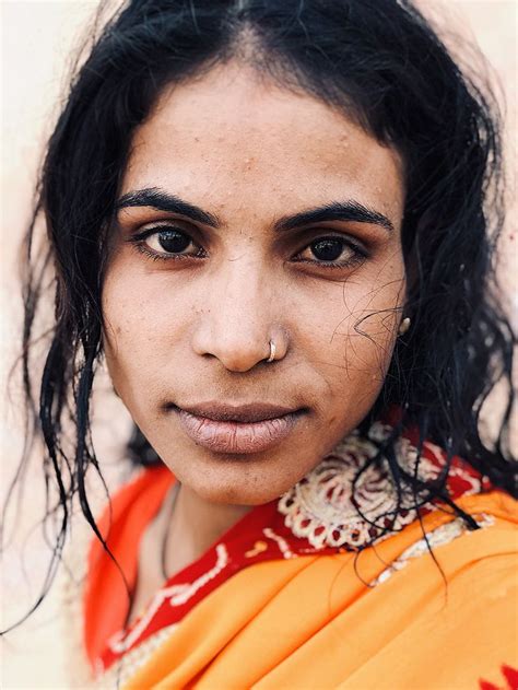 A Close Up Of A Person Wearing An Orange Sari And Looking At The Camera