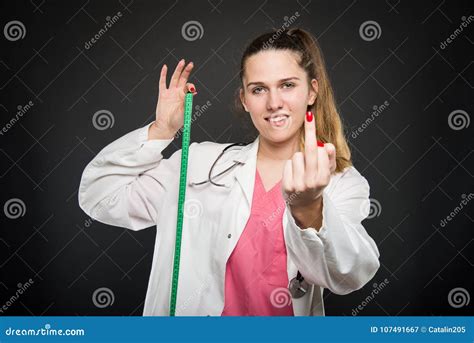 Female Doctor Holding Measuring Tape Showing Obscene Gesture Stock