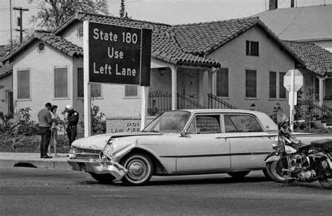 An Old Car Is Parked In Front Of A House With A Sign That Says State