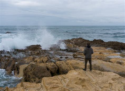 Traveler On The Rocks Near The Sea Looking Far Away At Horizon Rocky