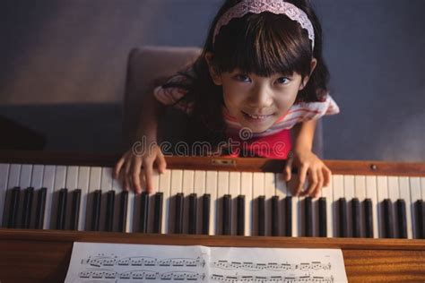 Overhead Portrait Of Girl Playing Piano In Classroom Editorial Image