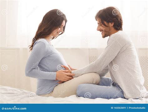 man touching belly of his pregnant wife in bed at home stock image image of care happiness
