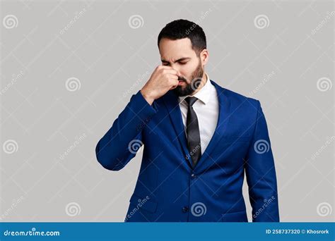 Man Grimacing With Disgust Holding Breath Pinching Nose With Fingers