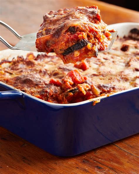 Eggplant Parmesan In Blue Baking Dish With Piece Sliced Out On A