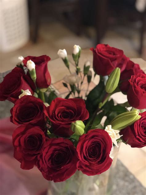 A Vase Filled With Red Roses On Top Of A Table