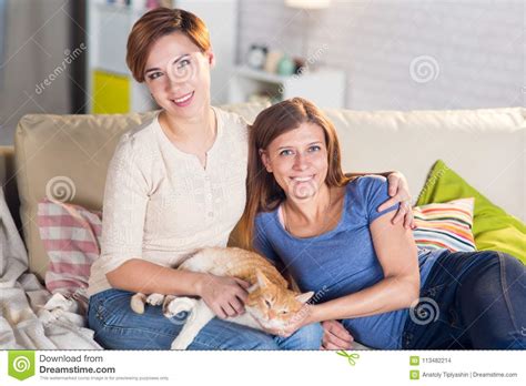 couples homosexuels des femmes lesbiennes à la maison sur le divan photo stock image du