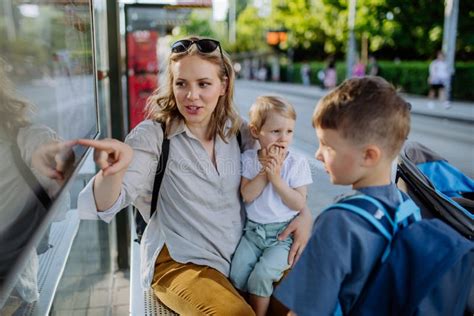 Young Mother With Little Kids Waiting On Bus Stop In City Stock Image