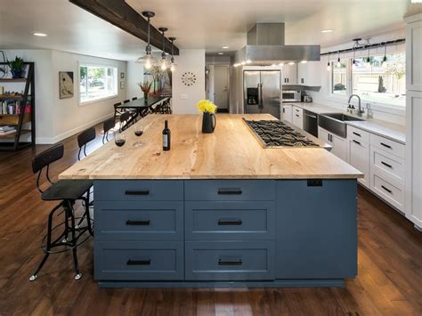 Blue butler's pantry cabinets are topped with a butcher block countertop and accented with brass knobs. blue island, butcher block countertop, and white perimeter ...