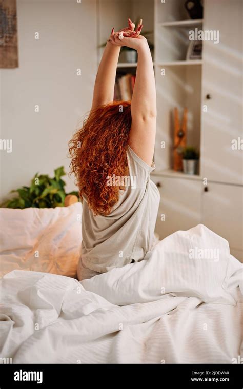 A Redhead Girl Wakes Up In The Morning And Stretches Her Arms Stock