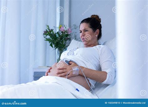 Pregnant Woman Suffering From Pain While Touching Her Belly In The Ward