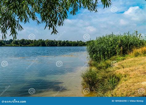 Picturesque Lake On A Sunny Day Light White Clouds In The Blue Sky