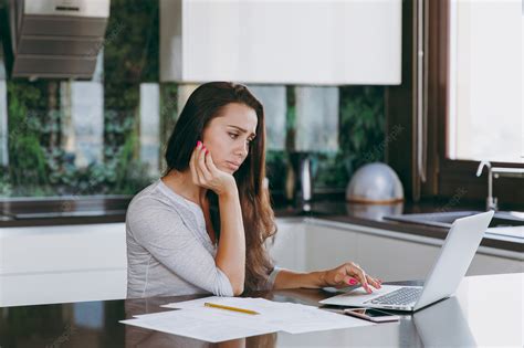 Free Photo The Attractive Pensive And Sad Business Woman Working With Documents And Laptop In