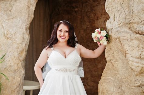 premium photo big breasts brunette bride with wedding bouquet posed at wedding hall background