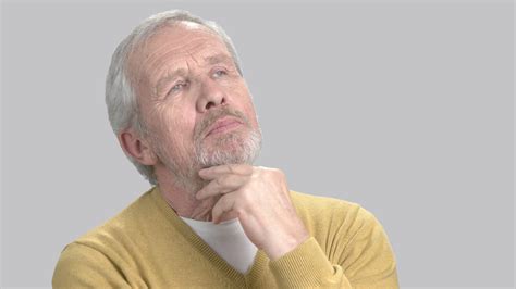 Portrait of thinking man, grey background. Caucasian elderly man 