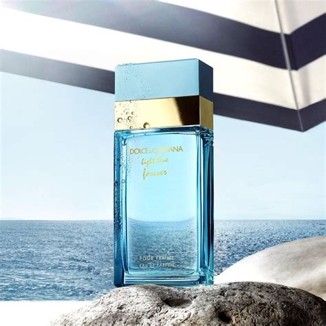 A Bottle Of Perfume Sitting On Top Of A Rock Near The Ocean With An