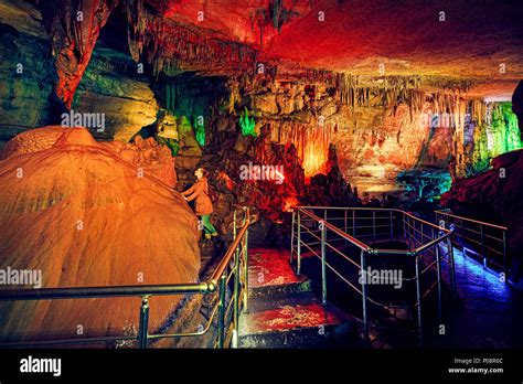 Tourist Woman In Underground Cave Sataplia With Colorful Illumination
