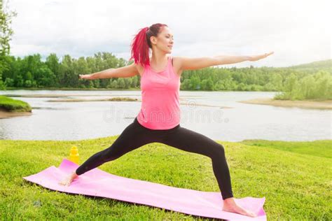 Young Woman Practicing Yoga In Beautiful Nature Lake Shore In Morning