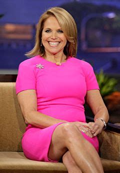 A Woman In A Pink Dress Is Sitting On A Couch And Smiling At The Camera