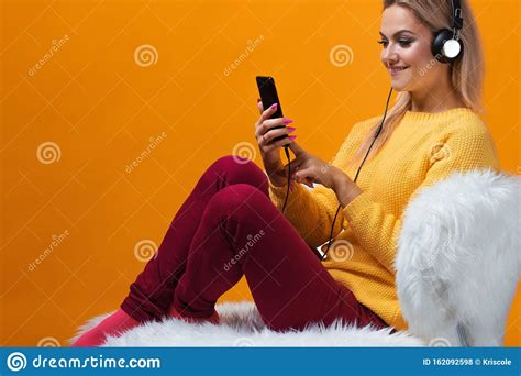 Happy And Cheerful Blonde With The Phone And Headphones Uses Voice