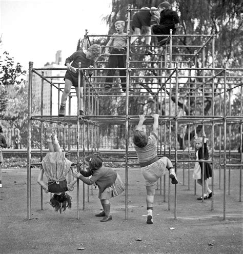 Children Climbing On Metal Monkey Bars Over Concrete In Central Park