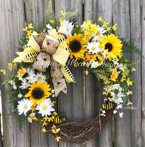 A Wreath With Sunflowers And Daisies On A Fence