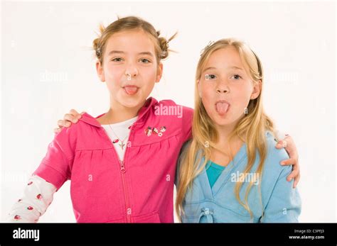 Two Girls Embracing Sticking Out Tongues Smiling Portrait Stock Photo Alamy