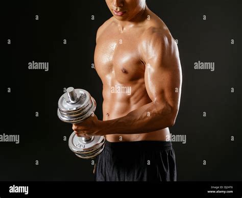 Photo Of An Asian Male Exercising With Dumbbells And Doing Bicep Curls
