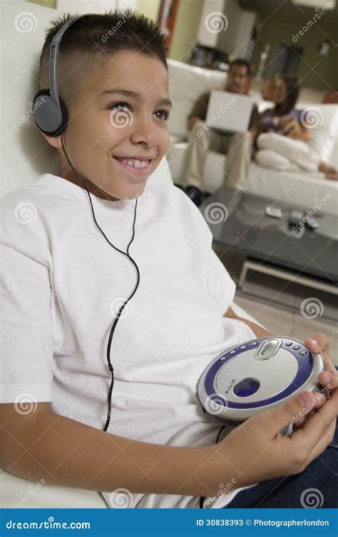 Boy Listening To Music On Portable Cd Player In Living Room Stock Image