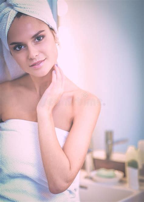 Young Attractive Woman Standing In Front Of Bathroom Mirror Stock Image
