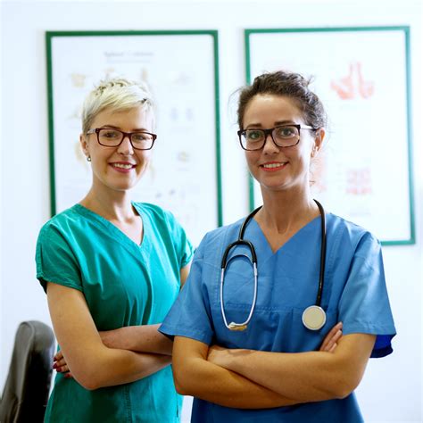 Portrait Of Two Professional Happy Nurses With Eyeglasses Standing In