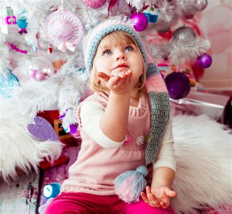Das Schöne Mädchen Das Nahe Weihnachtsbaum Sitzt Kostenlose Foto