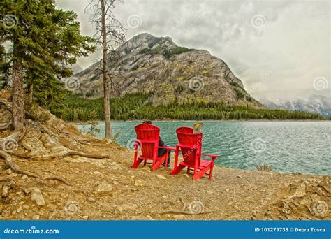 Red Adirondack Chairs Two Red Adirondack Chairs One Man Sit Front Lake Mountains Fog Banff 101279738 