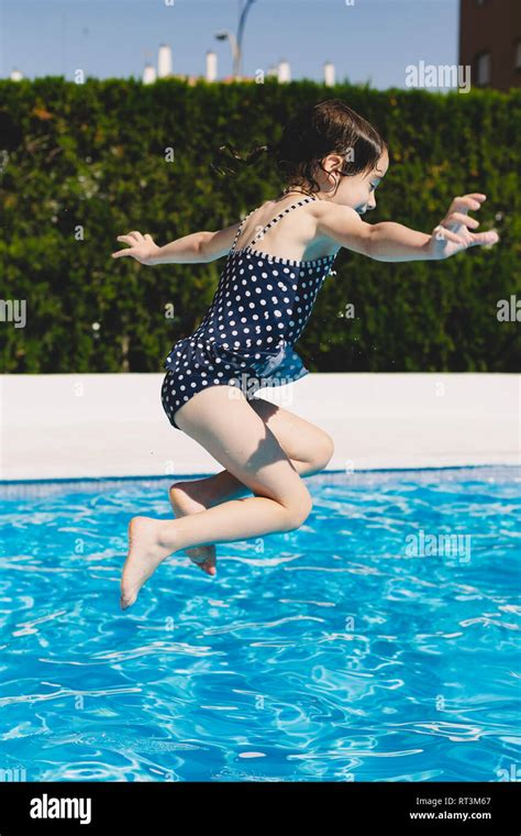 Happy Little Girl Jumping Into Swimming Pool Stock Photo Alamy